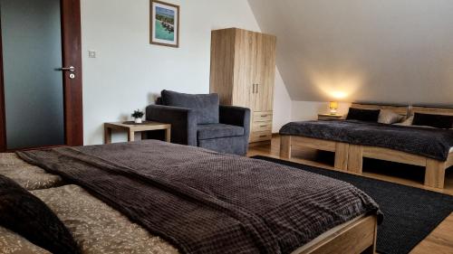 a bedroom with a bed and a couch and a chair at Ubytovanie Lenka in Osturňa