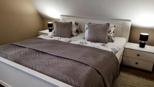 a bedroom with a large bed with two pillows at Ubytovanie Lenka in Osturňa