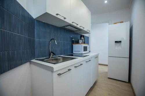 une cuisine avec un évier et un réfrigérateur dans l'établissement 108 - Beachside Renovated 1BR apt 5 min from Beach, à Cambrils