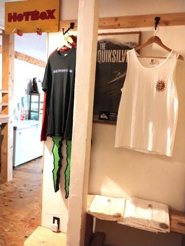 a room with a shelf with a shirt and a hanger at 伊豆 白浜 ゲストハウス茉心 in Shimoda