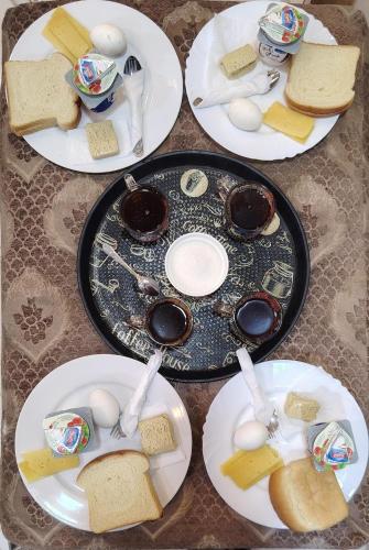a table with plates of food with eggs and bread at One Season Hotel in Cairo