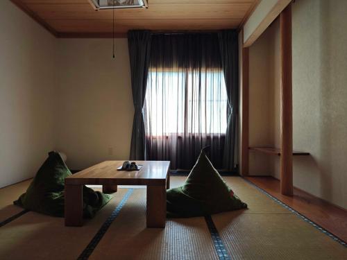 a living room with a table and green pillows at 層雲峡温泉 ホテル雲井 in Kamikawa
