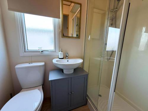 a bathroom with a toilet and a sink and a shower at Stunning Caravan With Wifi & Decking At St Osyth Beach In Essex Ref 28007Sv in Clacton-on-Sea