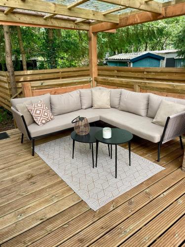 a couch and two chairs and a table on a patio at Heerlijke ruime stacaravan met overdekte veranda en omheinde tuin ''Casa Elvina'' in Eext
