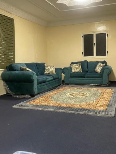 a living room with a blue couch and a rug at Sea hotel in Nouakchott