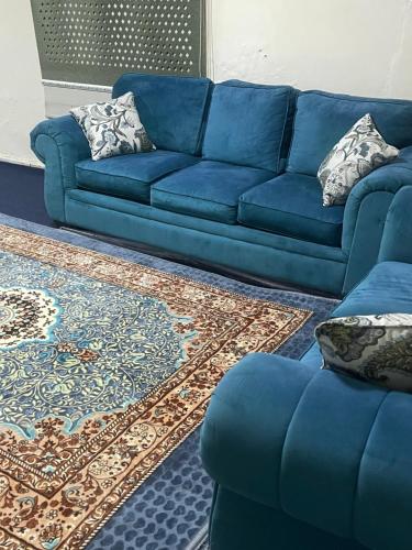 a blue couch in a living room with a rug at Sea hotel in Nouakchott