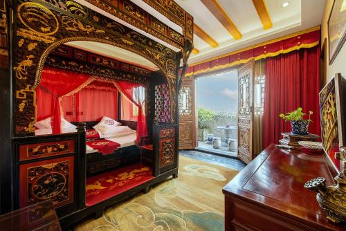 a bedroom with a large bed with red curtains at ChengDu Wuhou Temple Han Dynasty Hotel in Chengdu
