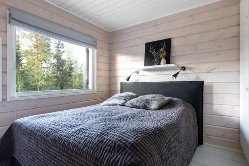 a bedroom with a bed with two pillows and a window at Tunturihovi A in Äkäslompolo