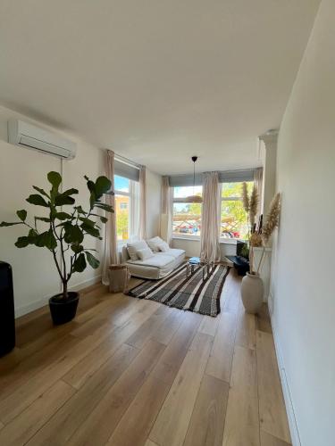 un soggiorno con un divano bianco e una grande finestra di Appartement aan de IJssel a IJsselmuiden