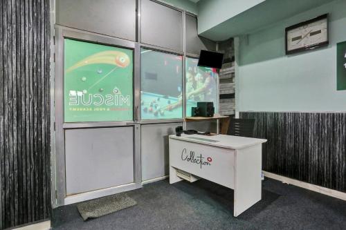 an office with a desk and a sign on the wall at Collection O The Miscue in Gurgaon