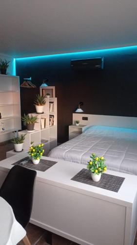ein Schlafzimmer mit einem weißen Bett und blauen Lichtern in der Unterkunft LoftCalJoan in Deltebre
