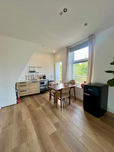 a living room with a table and a kitchen at Appartement aan de IJssel in IJsselmuiden