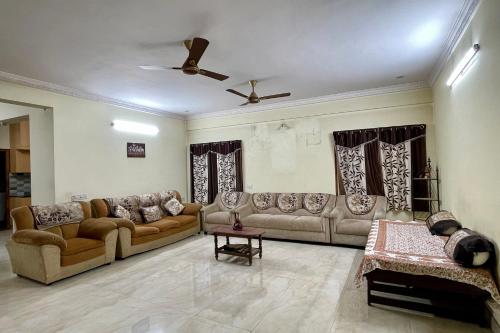 a living room with couches and a ceiling fan at Cozy Corner in Bengaluru