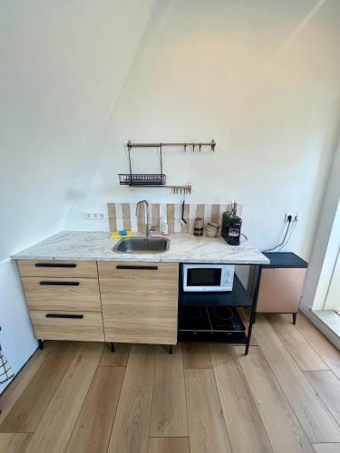a kitchen with a sink and a counter top at Appartement aan de IJssel in IJsselmuiden