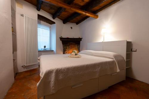 a bedroom with a large bed with a fireplace at Il Vicolo agli Orti - Centro storico - Lake Como in Bellano