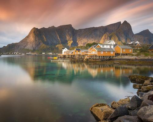 a group of houses on the shore of a body of water at Sakrisøy Gjestegård - Manor House in Sakrisøy - Solbakken anno 1880 in Reine