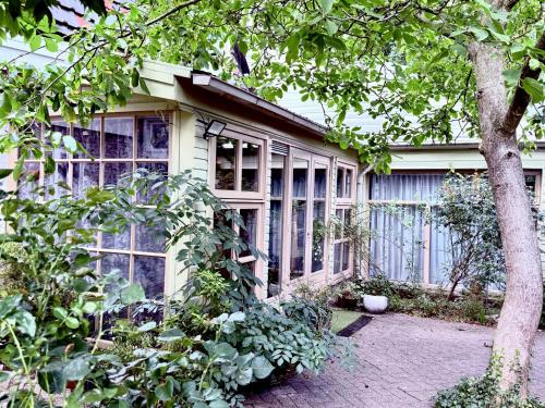 a house with a bunch of windows on it at Indigena Forest Retreat -Entire 6 persons Family home near Efteling and Dunes in Sprang-Capelle