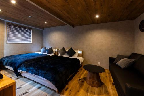 a bedroom with a bed and a table and a couch at tomarutoko OGUSU in Fukuoka