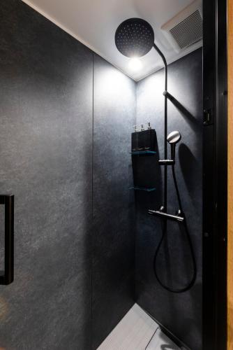 a bathroom with a shower with a glass door at tomarutoko OGUSU in Fukuoka