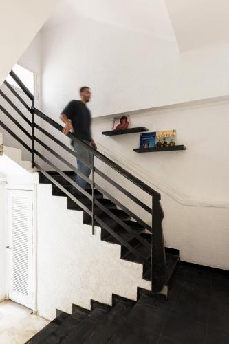 a man standing on the stairs of a house at Rena's House - Beach Edition in Tel Aviv