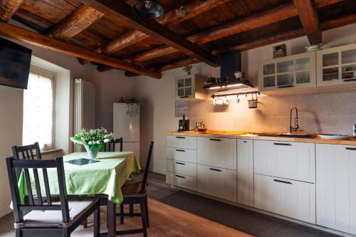 a kitchen with a table with a vase of flowers on it at Il Vicolo agli Orti - Centro storico - Lake Como in Bellano