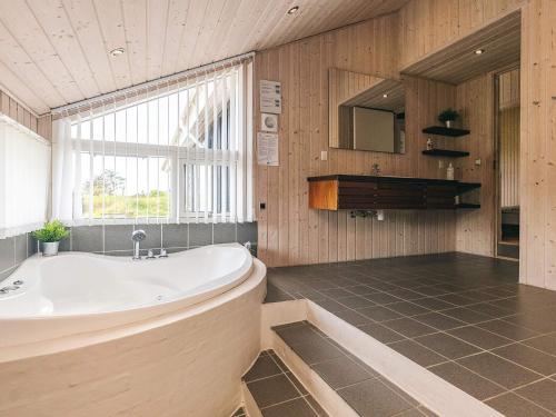 a large bathroom with a tub and a window at Modern Beach Retreat - By Traum Ferienwohnungen in Trudslev