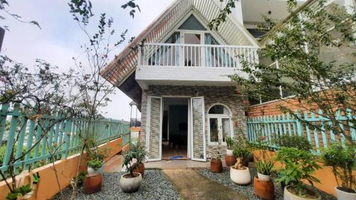 a house with a balcony and potted plants at NEST House in Ấp Kim Thạch