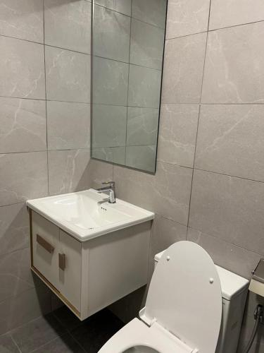 a bathroom with a toilet and a sink and a mirror at Majestic Residence Klcc in Kuala Lumpur
