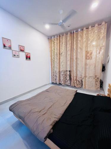 a bed in a room with a window at Cozy Studio by HoodSquare- NXone, 15 mins from Central Noida in Jāmb