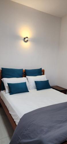 a large bed with blue and white pillows on it at Nayuha Beach New Penthouse B3 in Flic-en-Flac
