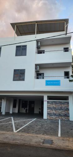 a white building with a parking lot in front of it at Nayuha Beach New Penthouse B3 in Flic-en-Flac