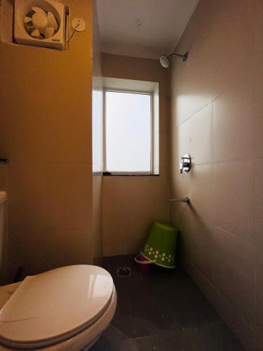 a bathroom with a white toilet and a window at Cozy Studio by HoodSquare- NXone, 15 mins from Central Noida in Jāmb