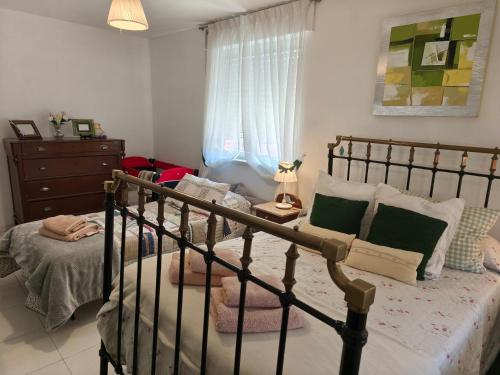 a bedroom with a bed and a dresser and a window at Casa Pita in San Justo de la Vega