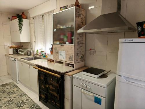 una cocina con fregadero y estufa horno superior en Casa Pita, en San Justo de la Vega