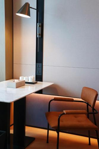 a desk with a chair and a lamp and a table at Four Points by Sheraton Nanning, Wuxiang in Nanning