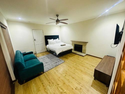 a bedroom with a bed and a couch and a fireplace at Joy House in Cape Town