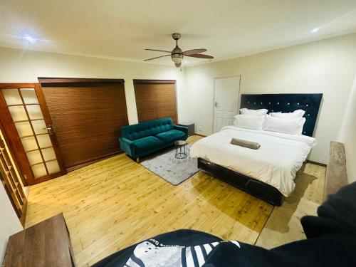 a bedroom with a bed and a green couch at Joy House in Cape Town