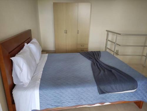 a bedroom with a bed with a blue blanket on it at Cozy Private Apartment Calheta in Arco da Calheta