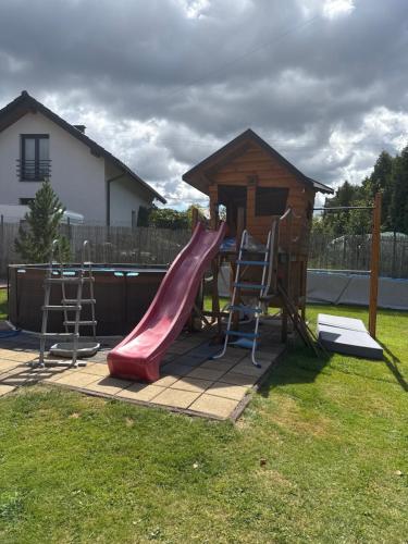 einen Spielplatz mit Rutsche und ein Haus in der Unterkunft Cichy Zaułek Górki Wielkie in Górki Wielkie