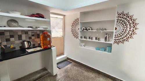 a kitchen with white walls and shelves and a window at Casa de Familia - 2BHK - Homestay - Manyata Tech Park - Hebbal Kempapura in Bengaluru