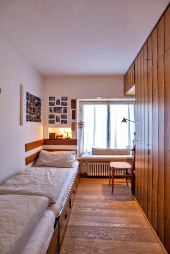 a bedroom with two beds and a window at Chesa Centrum 6pax - Celerina in Celerina