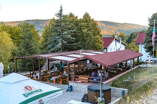 a restaurant with a roof with tables and benches at Комплекс Асеневци in Tsareva Livada