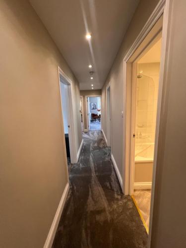 a hallway of a house with a hallway leading to a bathroom at Cherry Blossom Loft in Harrogate
