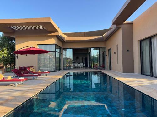a house with a swimming pool in front of a house at Villa Badia, 30 minutes médina, 4 suites, piscine in Oulad Mazoug