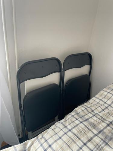 a pair of black beds in a room at Independent Cozy apartment in husby in Stockholm