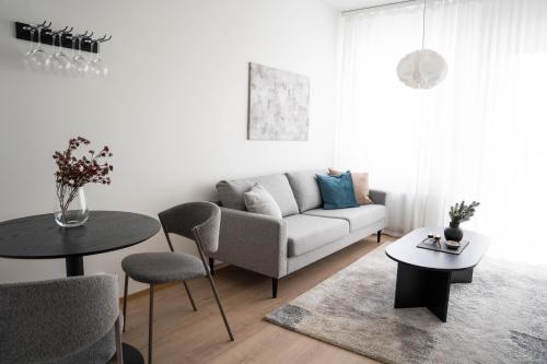 a living room with a couch and a table at Cozy Apartment With Sauna in the City Center - Lapnest in Rovaniemi