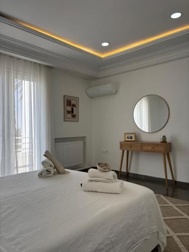 a bedroom with a large white bed with towels on it at Villa Le Domaine Djerba Piscine Chauffée sans vis à vis in Mezraya