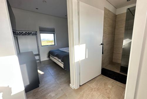 a bedroom with a bed and a walk in shower at Modern Holiday Home on the Golden Circle - Birta Rentals in Kerhraun