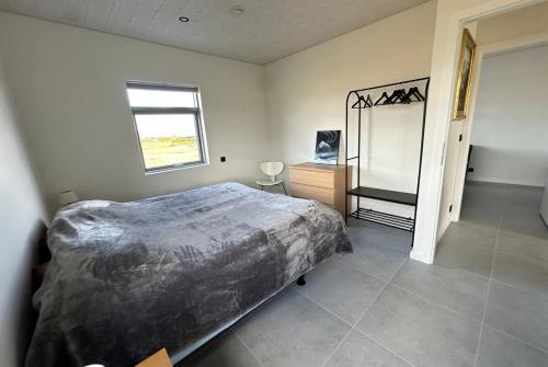 a bedroom with a large bed and a window at Modern Holiday Home on the Golden Circle - Birta Rentals in Kerhraun