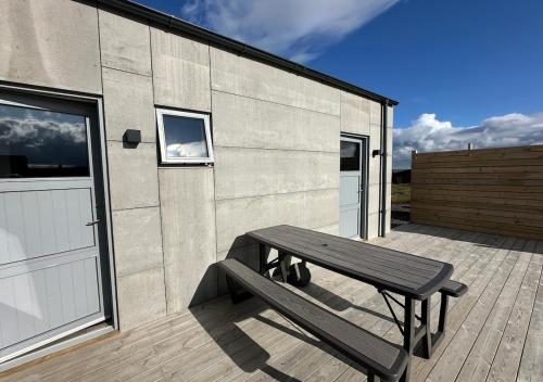 a wooden bench sitting on a deck next to a building at Modern Holiday Home on the Golden Circle - Birta Rentals in Kerhraun